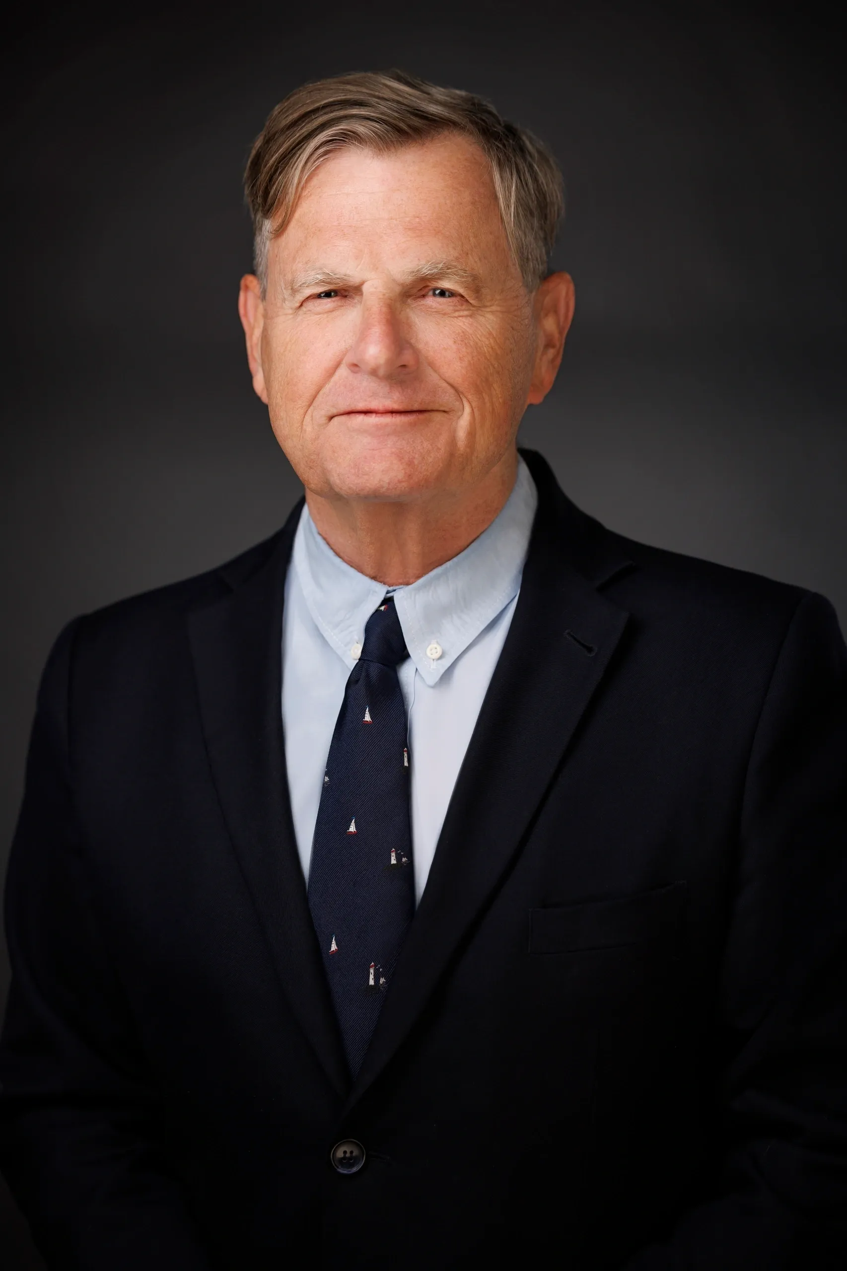 Man in suit with dark background.
