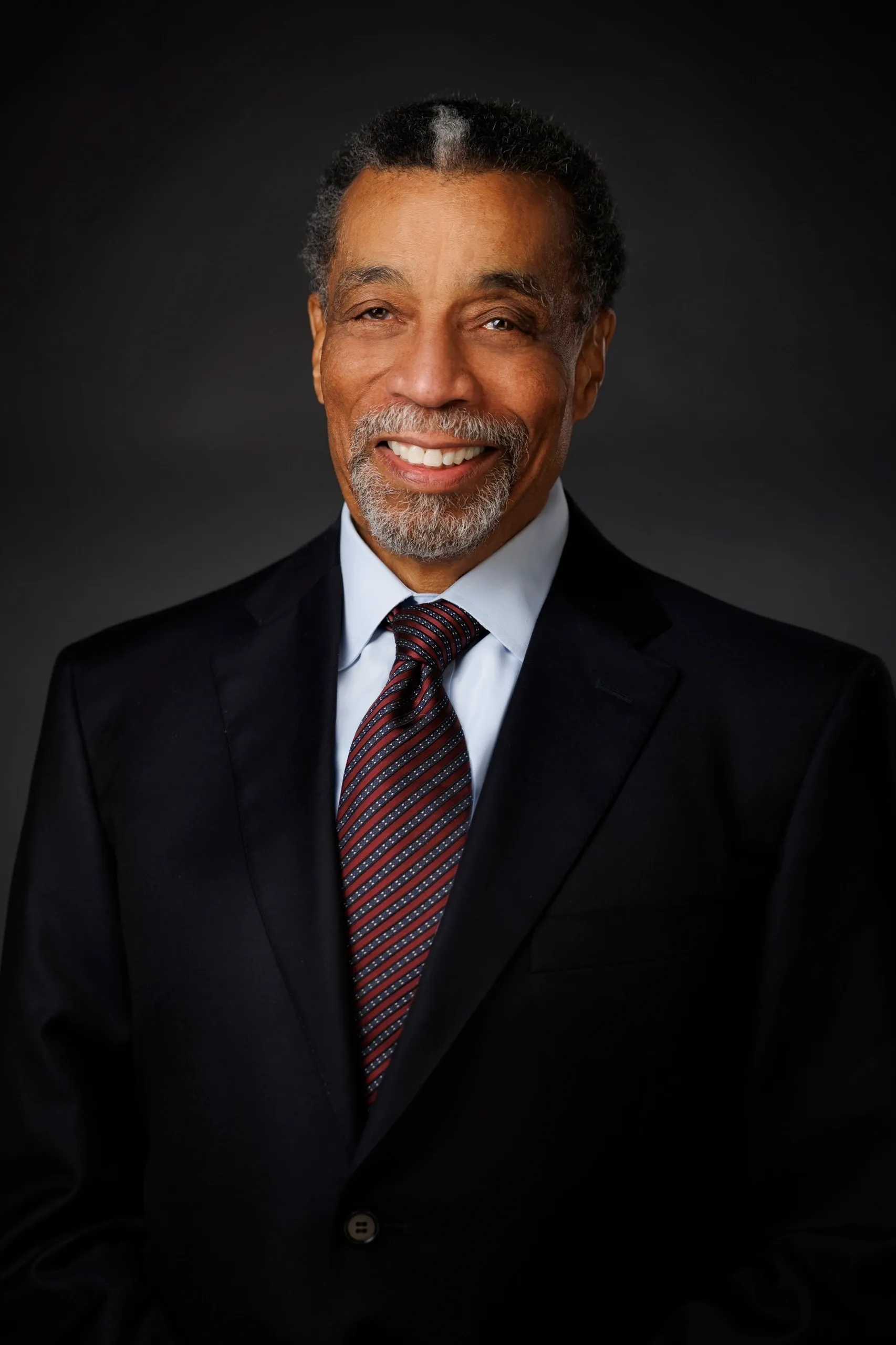 Smiling man in a suit and tie.
